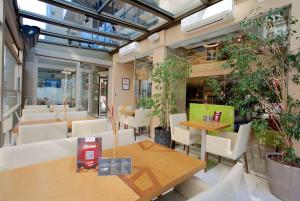 a restaurant with tables and chairs and potted plants at Ramada By Wyndham İstanbul Taksim in Istanbul