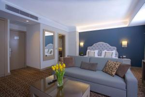 a living room with a couch and a bed at Ramada By Wyndham İstanbul Taksim in Istanbul