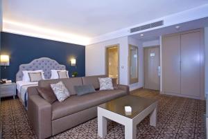 a living room with a couch and a bed at Ramada By Wyndham İstanbul Taksim in Istanbul