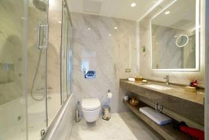 a bathroom with a shower and a toilet and a sink at Ramada By Wyndham İstanbul Taksim in Istanbul