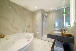 a large bathroom with a tub and a shower at Ramada By Wyndham İstanbul Taksim in Istanbul