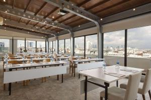 a restaurant with tables and chairs and large windows at Ramada By Wyndham İstanbul Taksim in Istanbul