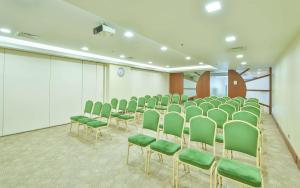 a conference room with green chairs and a screen at Ramada By Wyndham İstanbul Taksim in Istanbul
