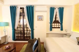 a bedroom with blue curtains and a bed and a table at Aria's Home in Hualien City