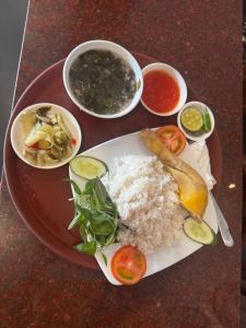 a plate of food with rice and vegetables on a table at Ha Long hotel in Ho Chi Minh City