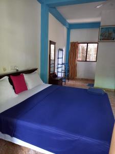 een slaapkamer met een groot blauw bed in een kamer bij Surf Kin Garden Inn in Weligama