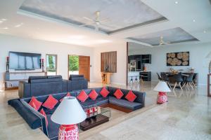 a living room with a blue couch and red pillows at Victoire Villa 4br Seaview in Mae Nam