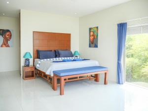 a bedroom with a large bed with a wooden headboard at Victoire Villa 3br Seaview Private Pool in Mae Nam +24 photos