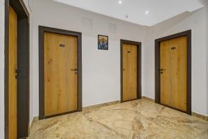 ハイデラバードにあるSuper Townhouse OAK Hitec City Near Image Hospitalの壁に木製のドアが3つある部屋