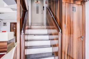 eine Treppe in einem Zimmer mit einer Holztür in der Unterkunft Super Collection O Sector 5 Sanpada Formerly Opal Comforts in Turambhe + 27 Fotos