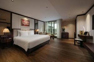 a bedroom with a large white bed and a desk at The Chi Boutique Hotel in Hanoi +94 photos