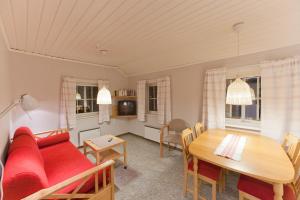 a living room with a red couch and a table at Lullens Stugby - Lägenhetshuset 6-9 in Bruksvallarna