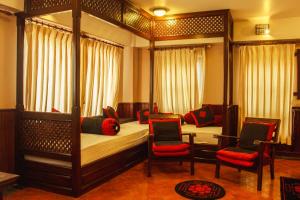 een slaapkamer met 2 stapelbedden en 2 stoelen bij Bhaktapur Paradise Hotel in Bhaktapur