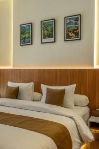 a bedroom with a large bed with four pictures on the wall at Balidian II Residence Loft 2 1 BR in Pesanggaran