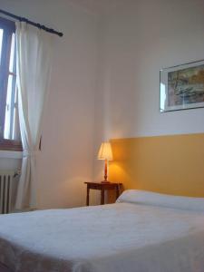 una camera con letto, lampada e finestra di Hôtel Restaurant Sole e Monte a Cuttoli-Corticchiato