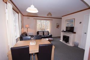 a living room with a table and a couch at Tullochwood Lodges in Forres