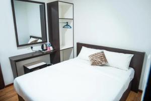 a bedroom with a white bed and a mirror at Shuang Ling Inn in Miri