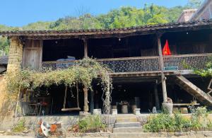 a building with a balcony with a flag on it at Vieille Maison de Ma Lé in Mia Si
