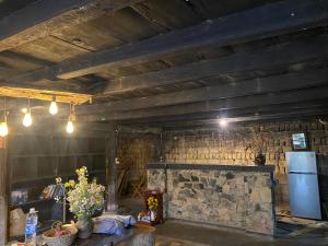 a kitchen with a refrigerator and a stone wall at Vieille Maison de Ma Lé in Mia Si