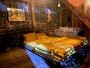 a large bed in a room with a brick wall at Vieille Maison de Ma Lé in Mia Si