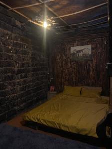 a bedroom with a bed and a brick wall at Vieille Maison de Ma Lé in Mia Si +6 photos