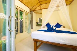 a bedroom with a bed with blue pillows at Bubble Bungalow in Ko Tao