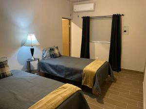 a room with two beds and a lamp and a window at LiV109 Norte Depa 4 Cd Obregon in Ciudad Obregón