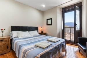 Un dormitorio con una cama grande y un balcón. en La Cerra, en Pajares 24 fotos más