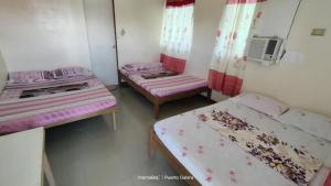 two beds in a room with pink and pink sheets at Residencia del Mundo - Hotel in Puerto Galera