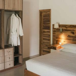 a bedroom with a white bed and a wooden wall at Villa Sebastiana Bungalows in Tarapoto