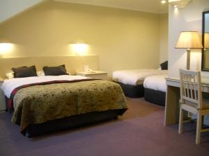 a hotel room with two beds and a chair at Perisher Manor Hotel in Perisher Valley