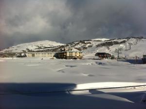un campo cubierto de nieve con una montaña en el fondo en Perisher Manor Hotel, en Perisher Valley