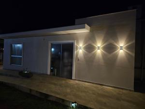 a house with two lights on the wall at night at Solar das Oliveiras in Ibertioga