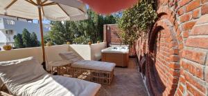a brick wall with an umbrella and chairs on a patio at Guesthouse Nut in Luxor