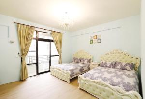 - une chambre avec 2 lits et une fenêtre dans l'établissement Princess Chloe B&B, à Hengchun Old Town