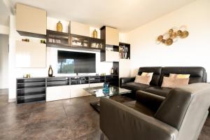 a living room with a leather couch and a table at Le Syrius in Nice