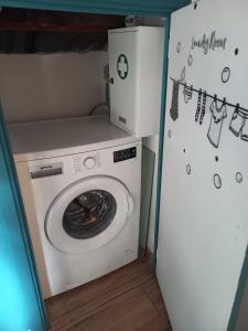 a washing machine in a laundry room with a refrigerator at vinga holiday's house in Imperia
