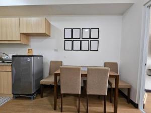 a kitchen with a dining room table and chairs at The Celandine Balintawak "Ahh-Mazing Suite" Quezon City in Quezon City
