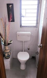 a small bathroom with a toilet and a window at Soho by the Ganges Riverside in Nangi