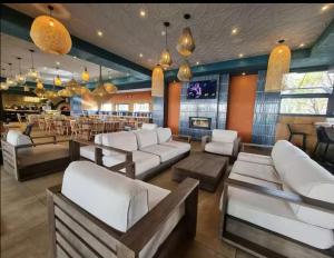 a restaurant with white couches and a bar at The Blyde lagoon Penthouse in Pretoria