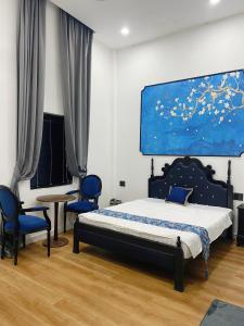 a bedroom with a bed and two blue chairs at LV Homestay in Nha Trang