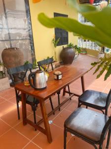 a wooden table and chairs with a tea kettle on it at LV Homestay in Nha Trang