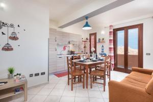 una cucina e una sala da pranzo con tavolo e sedie di Sea and sand Apartment a San Vito lo Capo