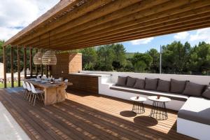 a wooden deck with a couch and a table at Villa Can Pep de Sa Guaita Amaizing Design & Outdoor Area 10 minutes from beaches Calm Area in Ibiza Town +37 photos