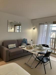 ein Wohnzimmer mit Sofa und Tisch in der Unterkunft Grand studio hyper centre avec balcon TOUT REFAIT MARS 2025 in Deauville