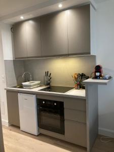 eine Küche mit Spüle und Herd in der Unterkunft Grand studio hyper centre avec balcon TOUT REFAIT MARS 2025 in Deauville + 15 Fotos