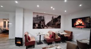 a restaurant with two tables and chairs and a fireplace at hôtel- restaurant le Saint Quentin in Saint-Quentin