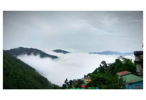 a view of a mountain with a bunch of clouds at Sunshraya Homestay in Darjeeling