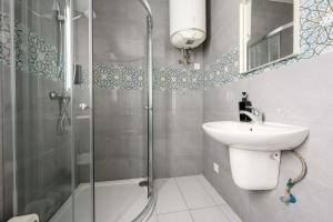 um banheiro com chuveiro, pia e espelho em F9 Modern and Bright Apartment in Malta em Msida mais 53 fotografias