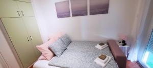 a small bedroom with a bed and two pictures on the wall at Kuczkó Apartman in Balatonalmádi